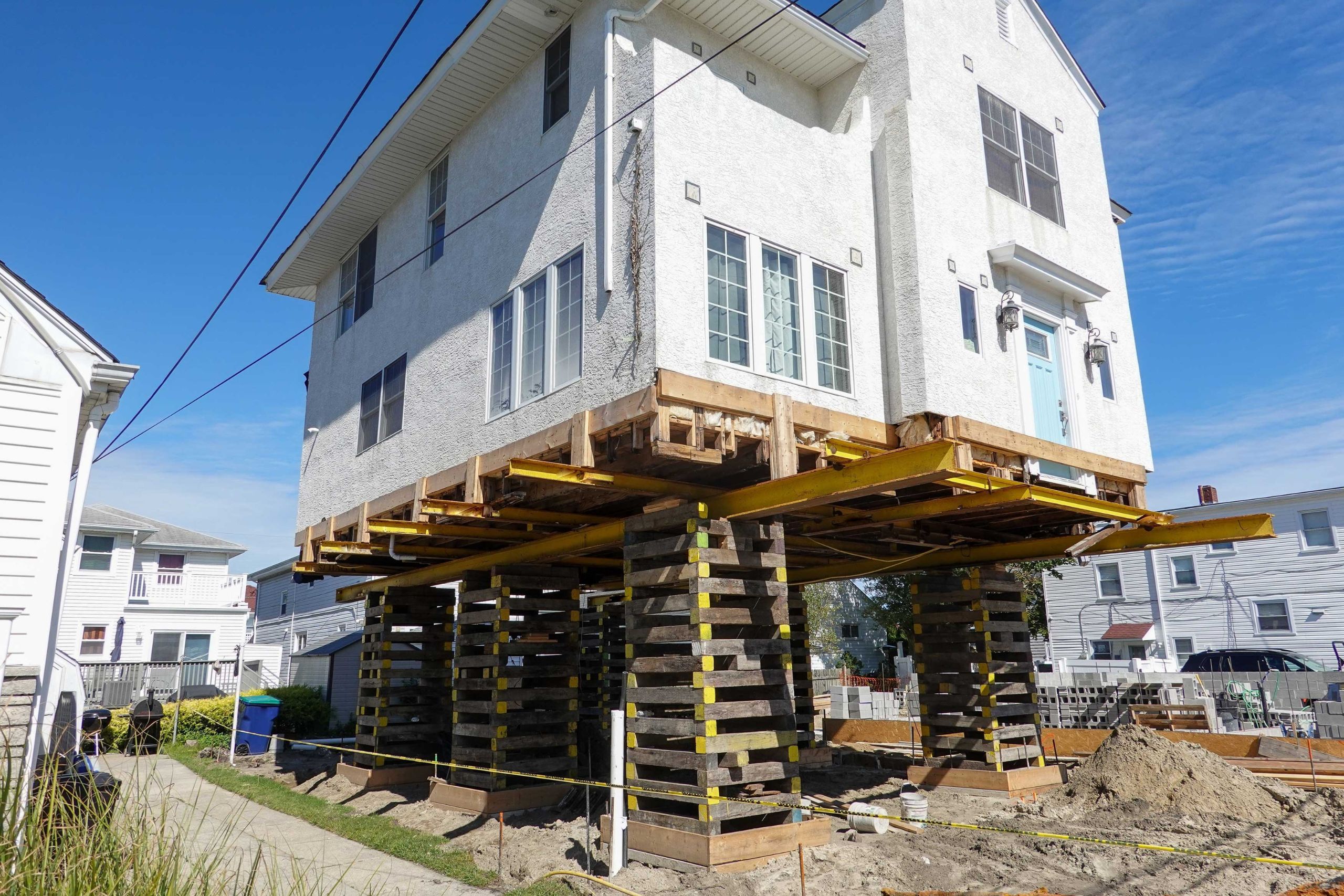 A team of professionals using specialized equipment to raise a house in Newark, preparing it for elevation and renovation